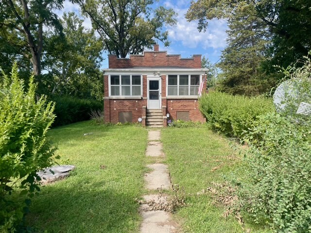 a front view of a house with yard and green space