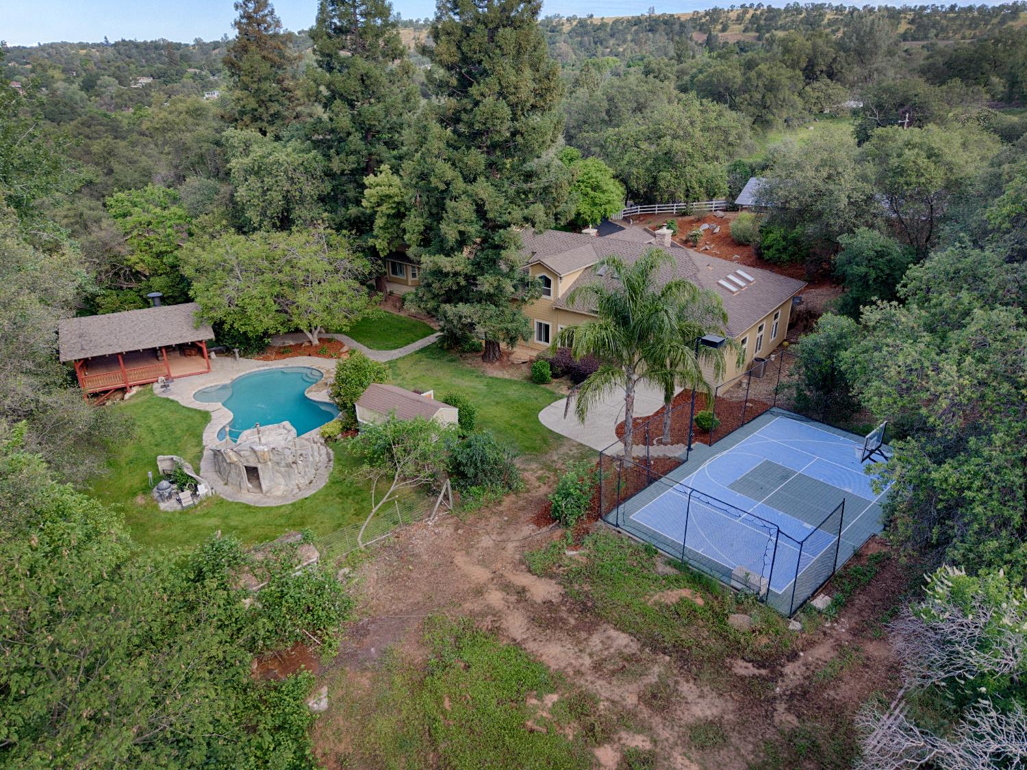 7396 Callison Road Penryn, CA 95663 - Photo 6 of 99 Aerial view of the property showcasing the pool, lighted sports court, and beautiful grounds