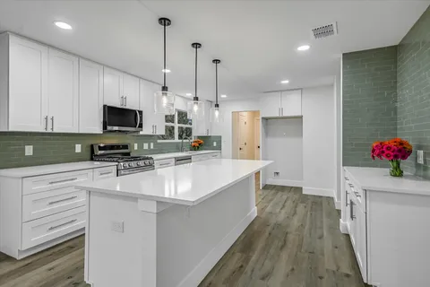 a kitchen with stainless steel appliances a stove refrigerator sink and microwave