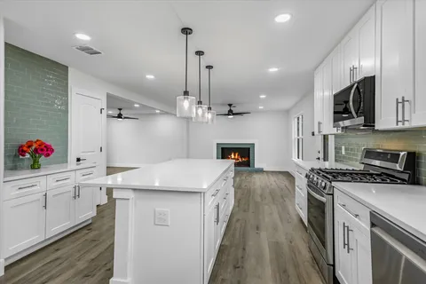 a kitchen with kitchen island a sink stove and cabinets
