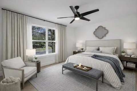 a bedroom with a bed a couch and a window