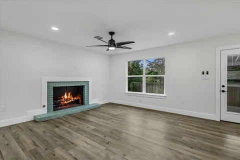an empty room with windows a fireplace and a fireplace