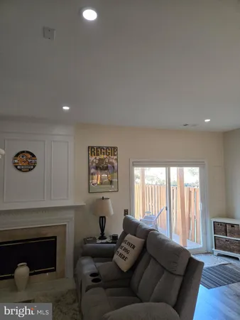 a living room with furniture a fireplace and a floor to ceiling window