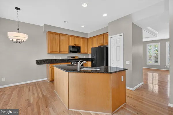 a kitchen with granite countertop a stove top oven microwave and cabinets