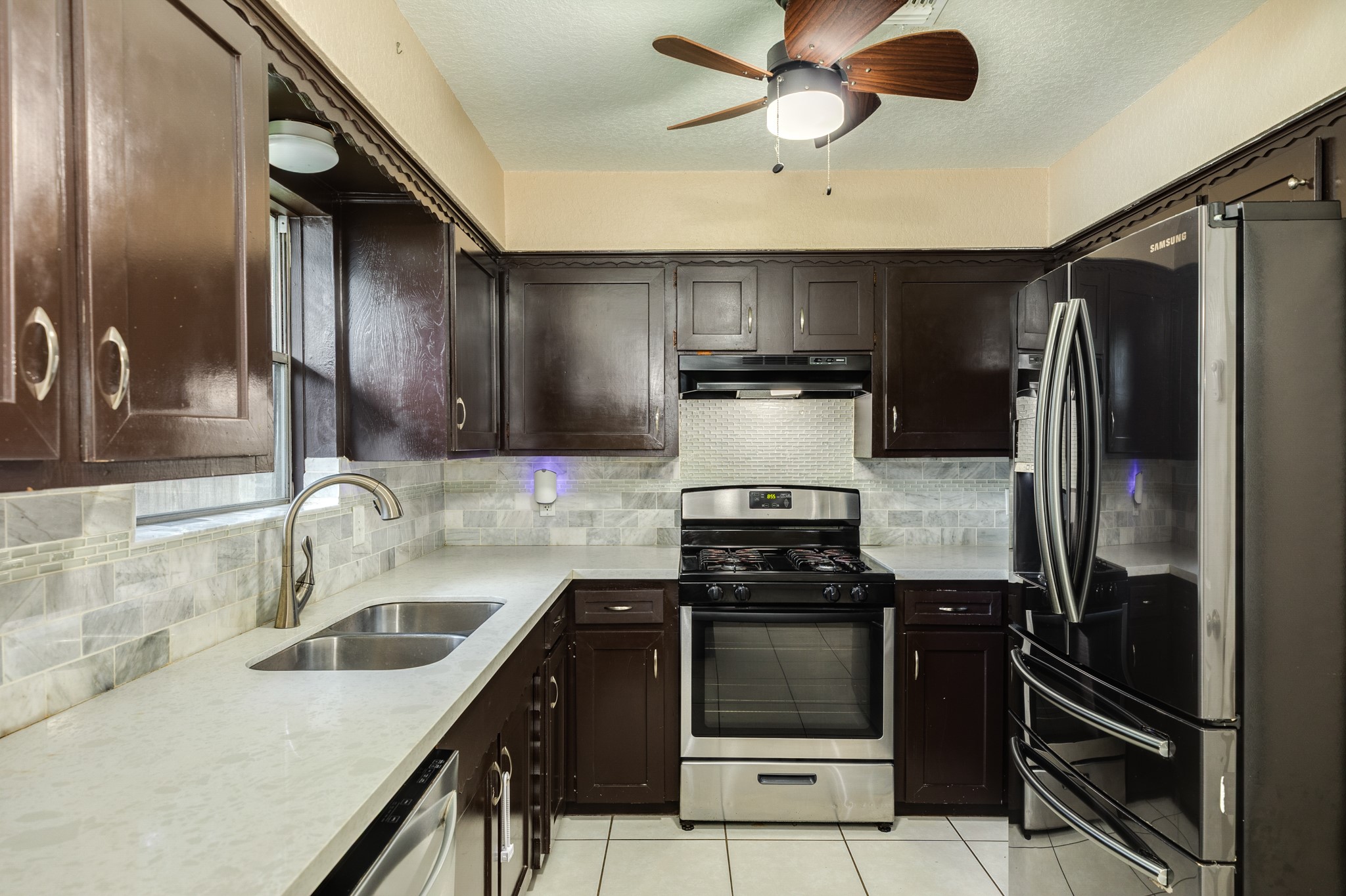 128 Houston Street Angleton, TX 77515 - Photo 9 of 25 a kitchen with stainless steel appliances granite countertop a sink stove and refrigerator