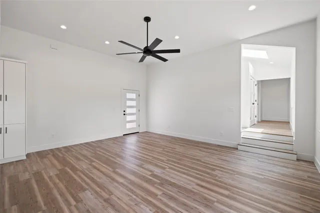 a view of room with wooden floor and ceiling fan