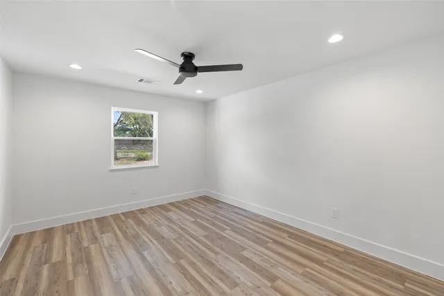 a view of a room with wooden floor and a ceiling fan