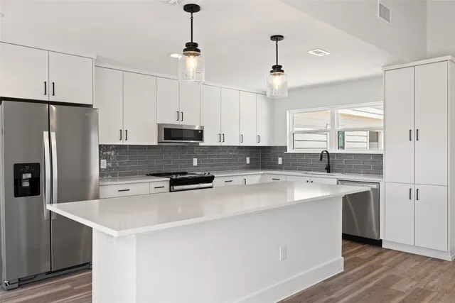 a kitchen with granite countertop a stove and a wooden floor