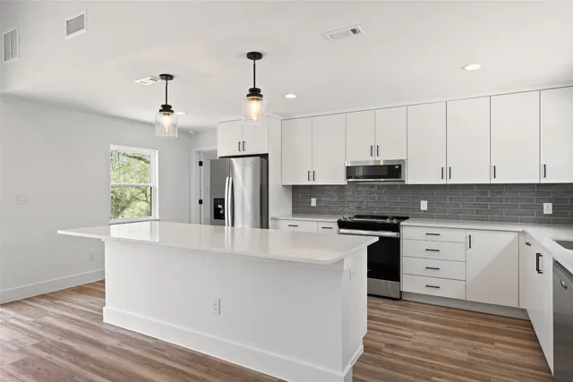 a kitchen with granite countertop white cabinets and white appliances