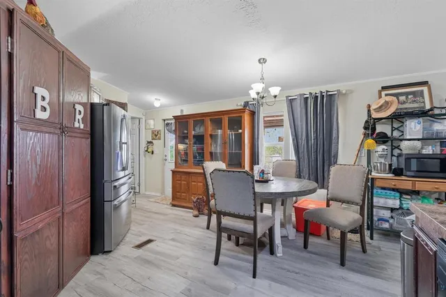a dining room with furniture a chandelier and wooden floor