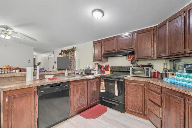 a kitchen with kitchen island granite countertop wooden cabinets and a sink