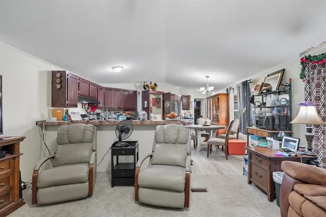a living room with furniture and a kitchen view