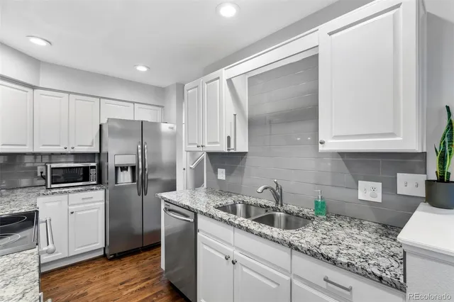 a kitchen with stainless steel appliances granite countertop a refrigerator sink and cabinets
