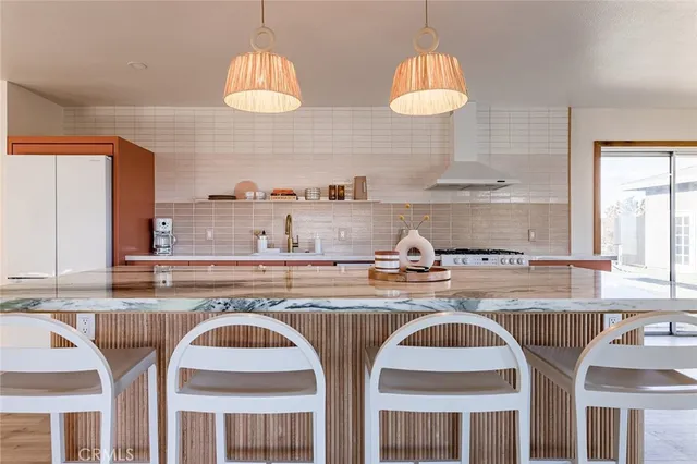 a kitchen with stainless steel appliances granite countertop a stove a sink and a dining table