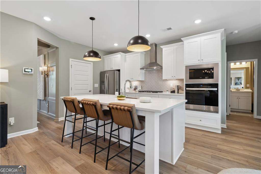 412 Hartsfield Road McDonough, GA 30253 - Photo 18 of 43 a kitchen with a table chairs refrigerator and microwave
