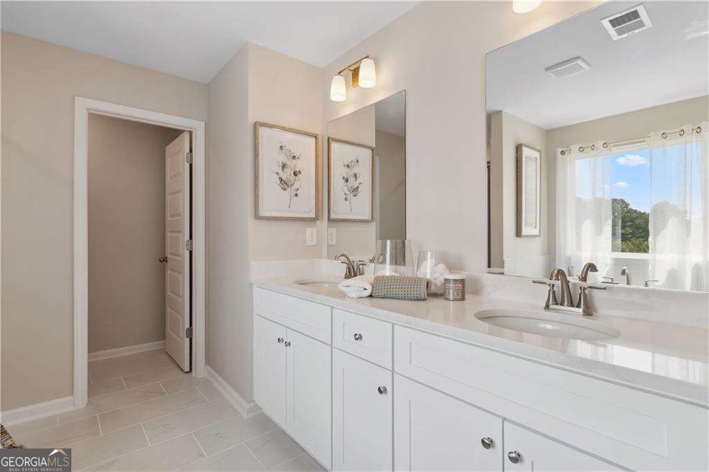412 Hartsfield Road McDonough, GA 30253 - Photo 41 of 43 a bathroom with double vanity sinks a vanity and a large mirror