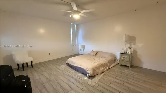 a bedroom with a bed and ceiling fan