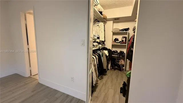 a view of a hallway with wooden floor and closet