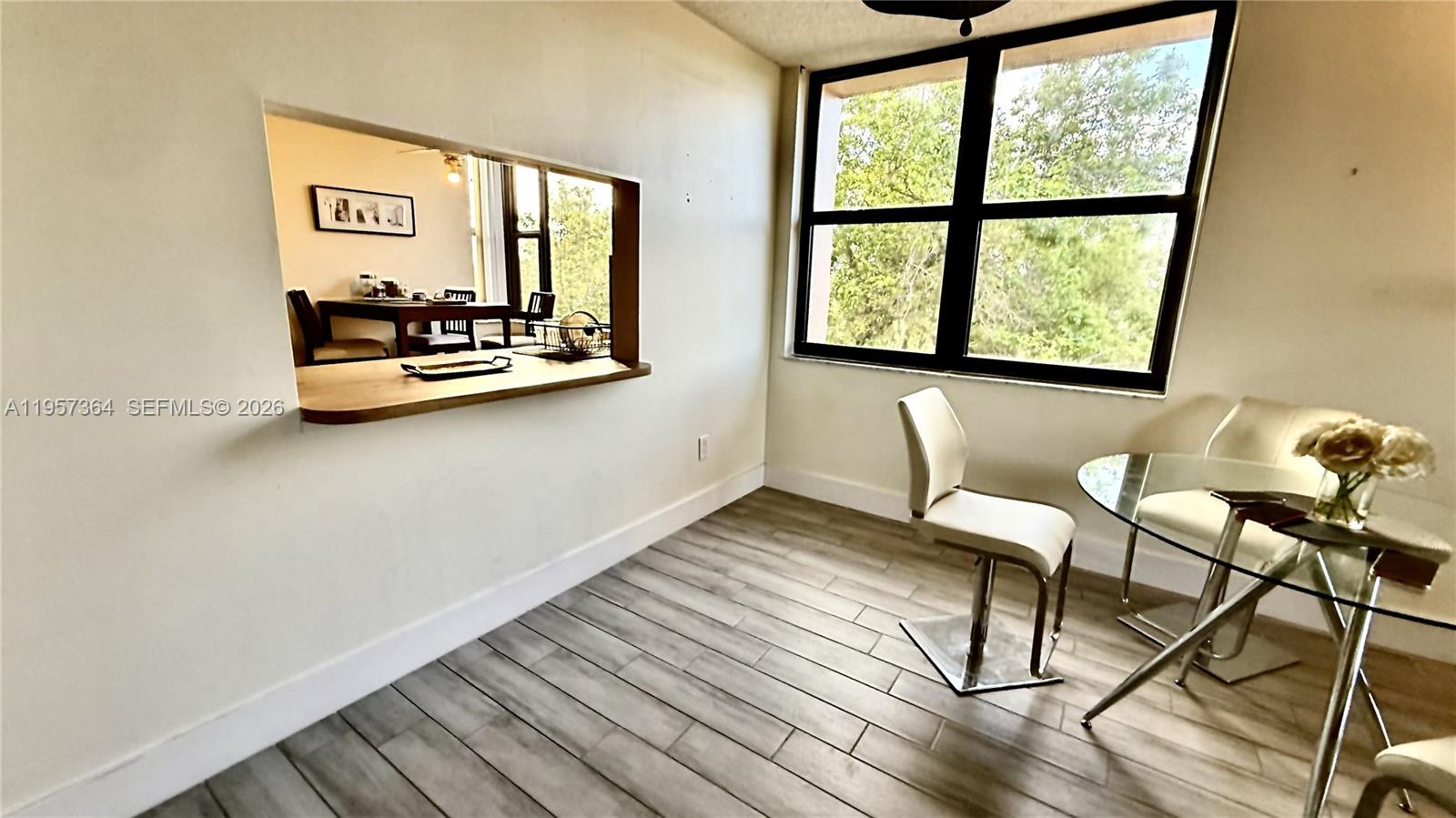6800 Cypress Road, Unit 501 Plantation, FL 33317 - Photo 17 of 40 a view of dining room and livingroom with furniture wooden floor a rug and a large window