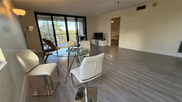 a living room with furniture a large window and wooden floor