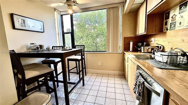 a kitchen with a table chairs sink and cabinets