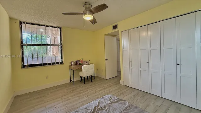 a view of a room with wooden floor fan and windows