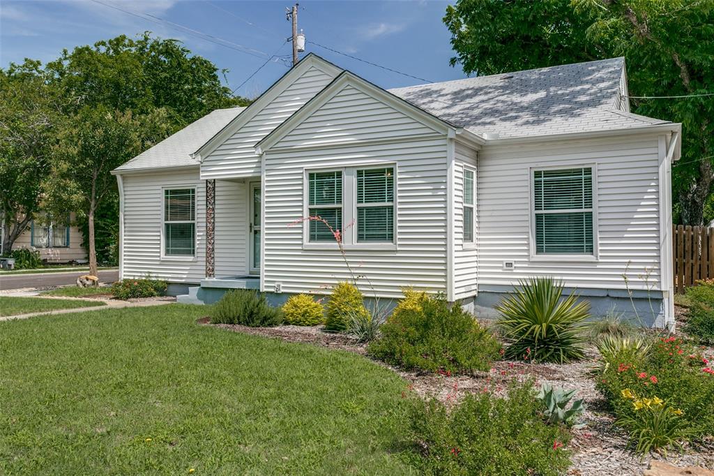 a view of a house with a yard and potted plants
