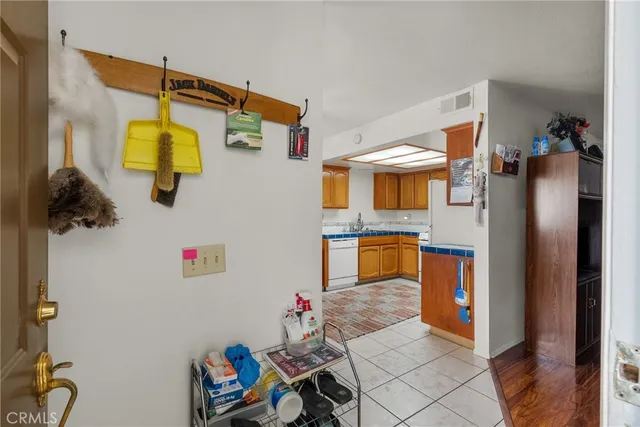 a kitchen with stainless steel appliances granite countertop a sink dishwasher a stove a dining table and chairs with wooden floor