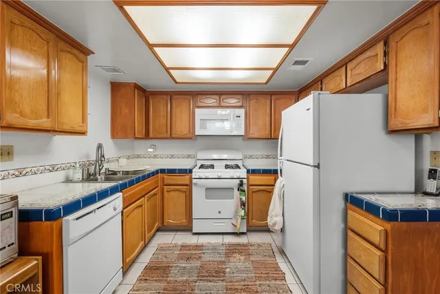 a kitchen with stainless steel appliances granite countertop a refrigerator sink and stove