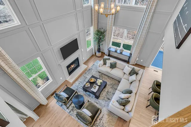 a living room with furniture a fireplace and a floor to ceiling window