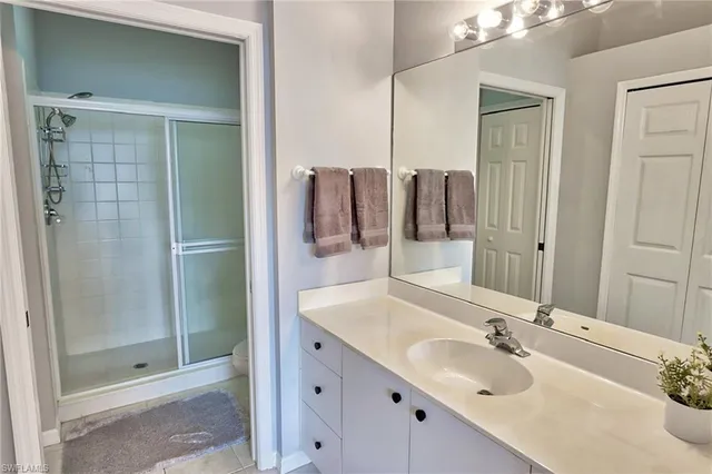 a bathroom with a double vanity sink mirror and shower