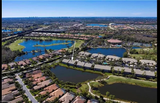 an aerial view of a city with lots of residential buildings ocean and mountain view in back