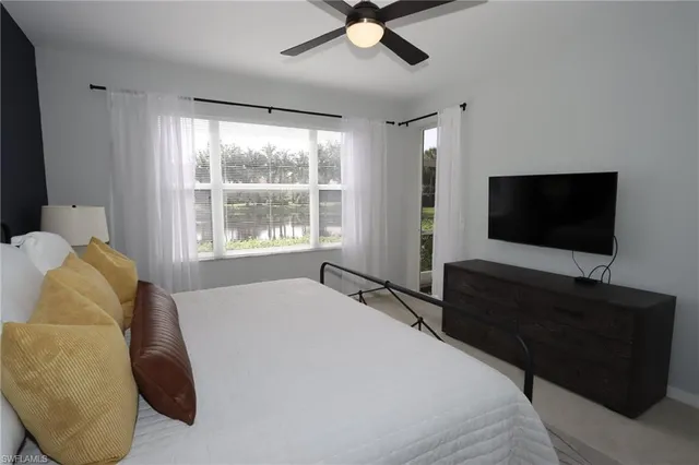 a bedroom with a bed window and a flat screen tv