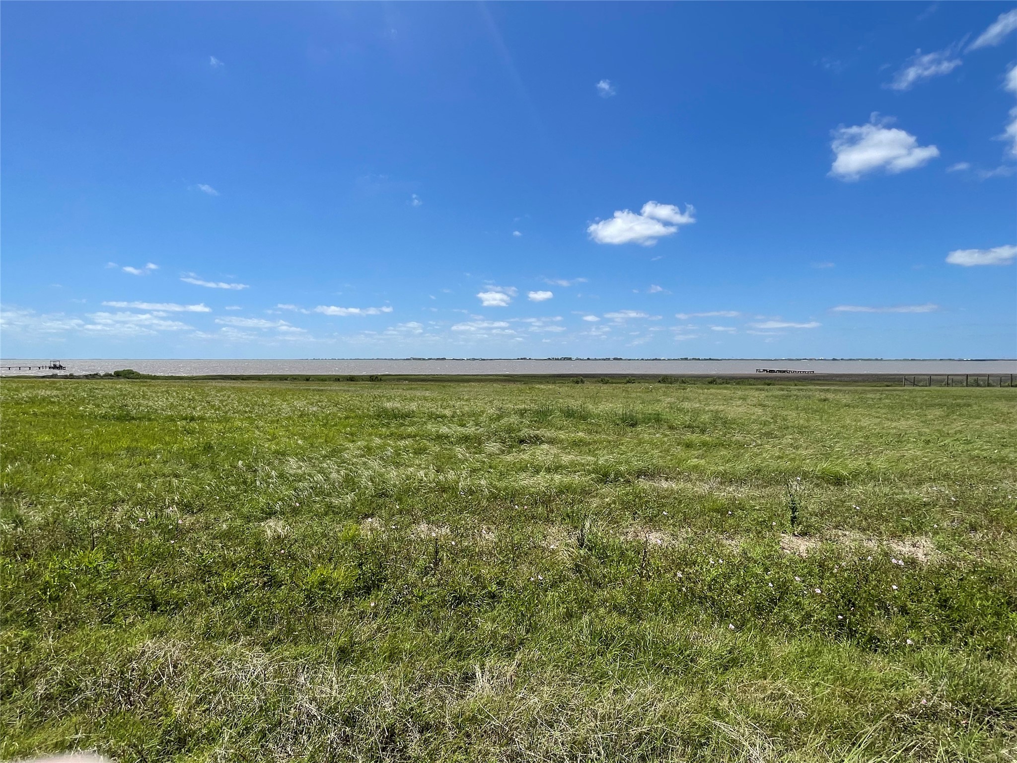 a view of a large green field with an ocean view
