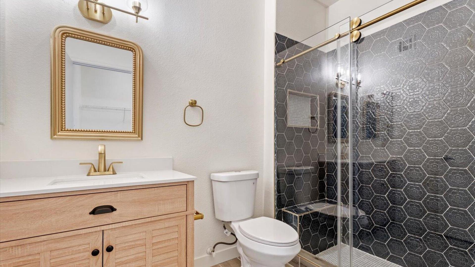 3434 East Baseline Road, Unit 260 Phoenix, AZ 85042 - Photo 4 of 19 a bathroom with a toilet a sink a glass door a shower a mirror and vanity