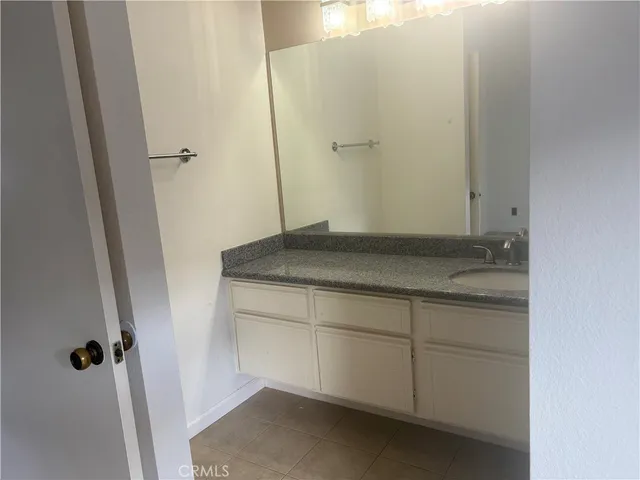 a bathroom with a granite countertop toilet and a sink