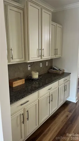 a kitchen with granite countertop white cabinets and sink