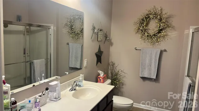 a bathroom with a sink vanity mirror and toilet