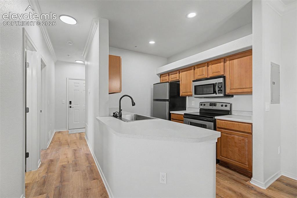 5353 Palomino Ranch Point, Unit 307 Colorado Springs, CO 80922 - Photo 7 of 30 Light wood cabinetry, solid-surface countertops, and stainless steel appliances