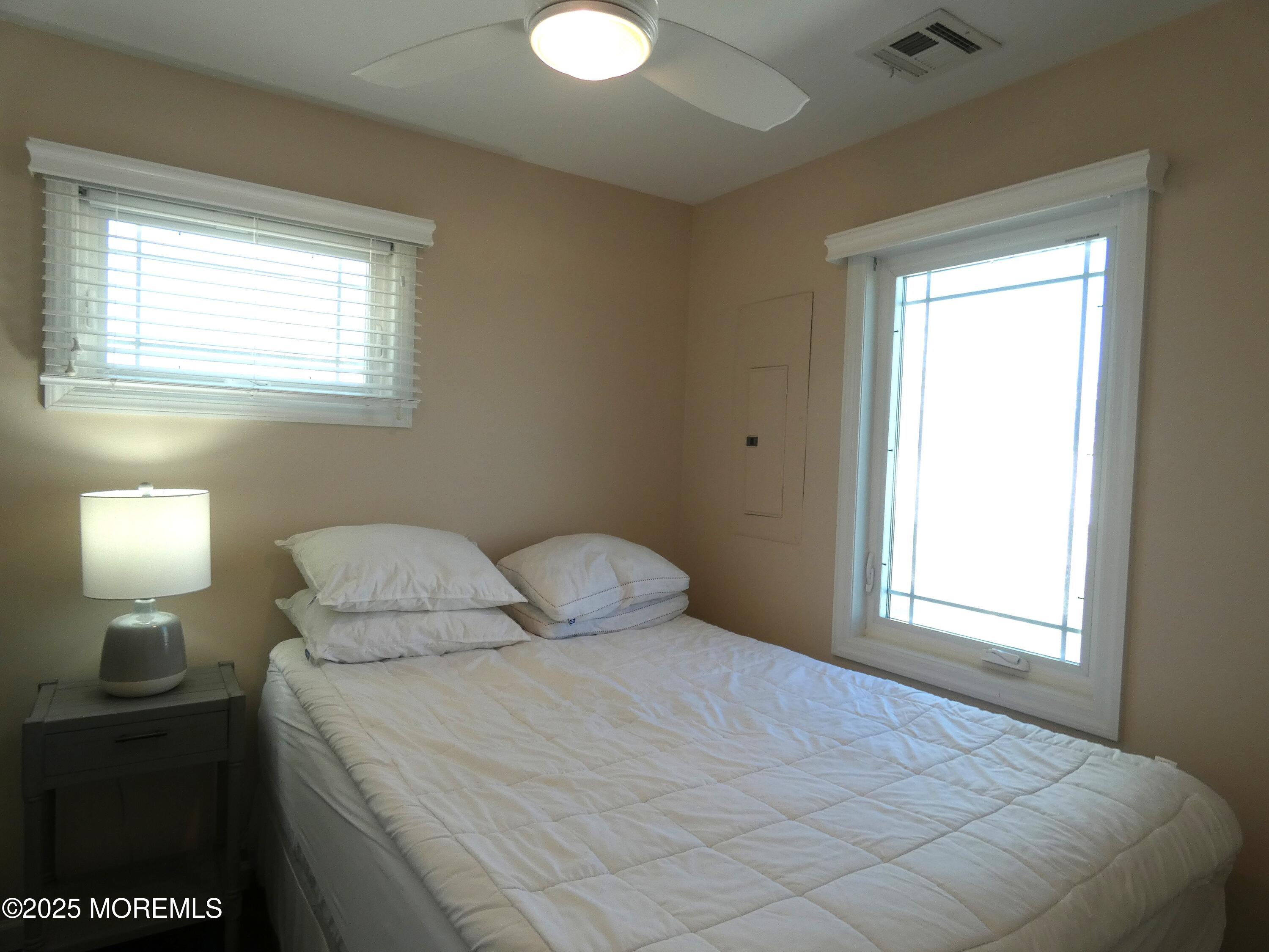 3420 Seaview Road Lavallette, NJ 08735 - Photo 20 of 44 a bedroom with a bed and a lamp next to a window