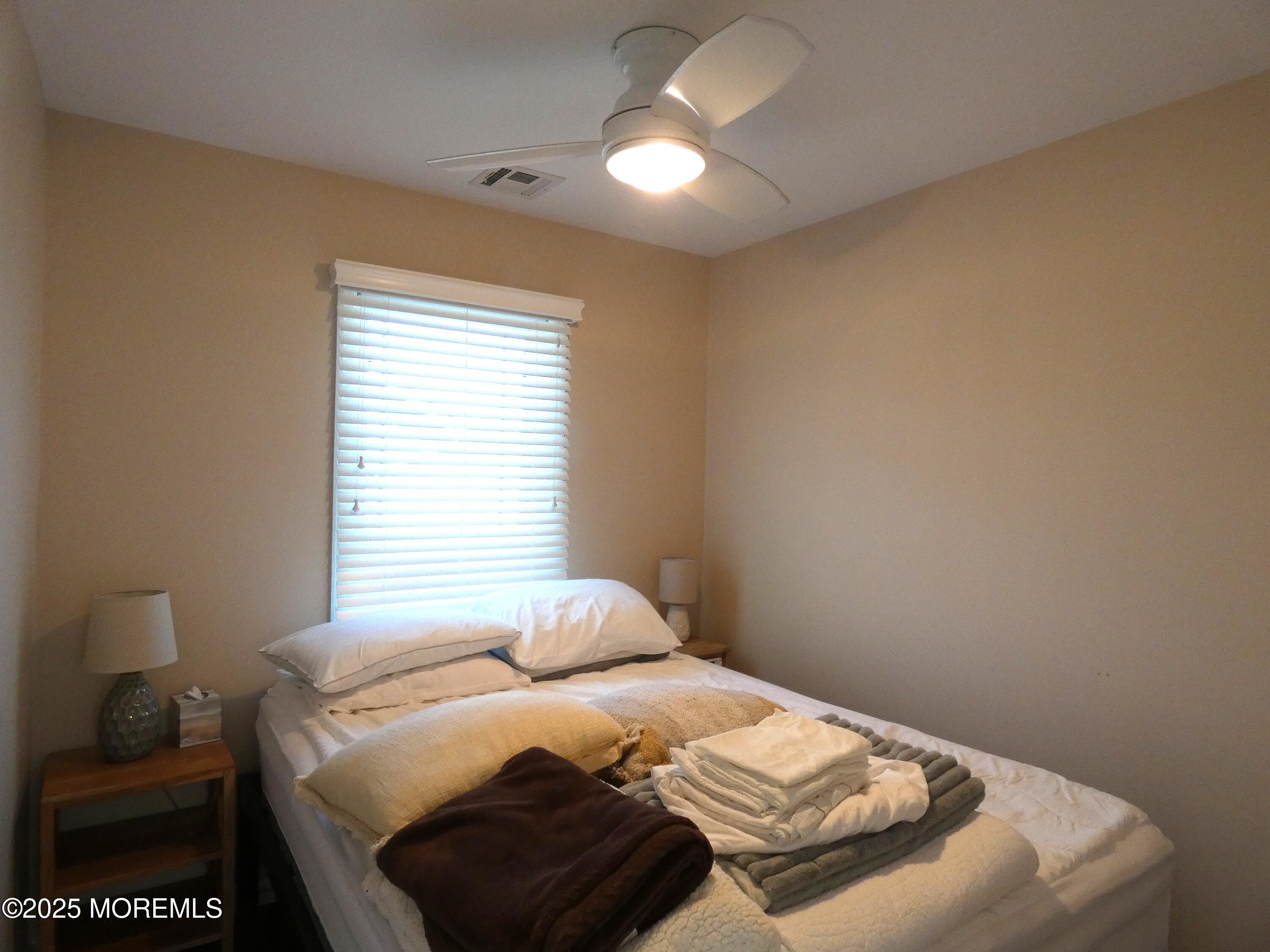3420 Seaview Road Lavallette, NJ 08735 - Photo 22 of 44 a bedroom with a bed and a lamp with window