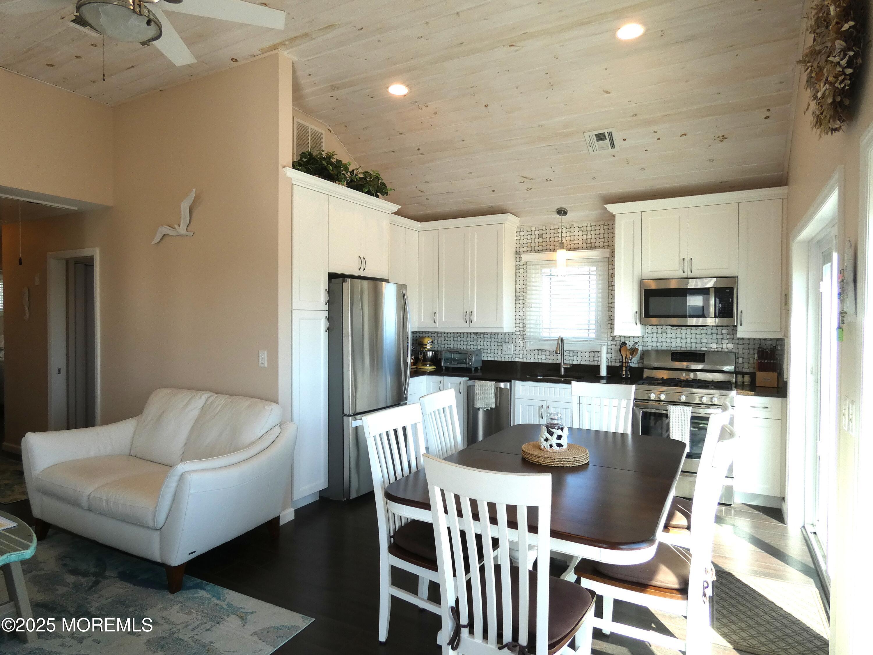 3420 Seaview Road Lavallette, NJ 08735 - Photo 7 of 44 a kitchen with stainless steel appliances granite countertop a dining table chairs microwave and sink