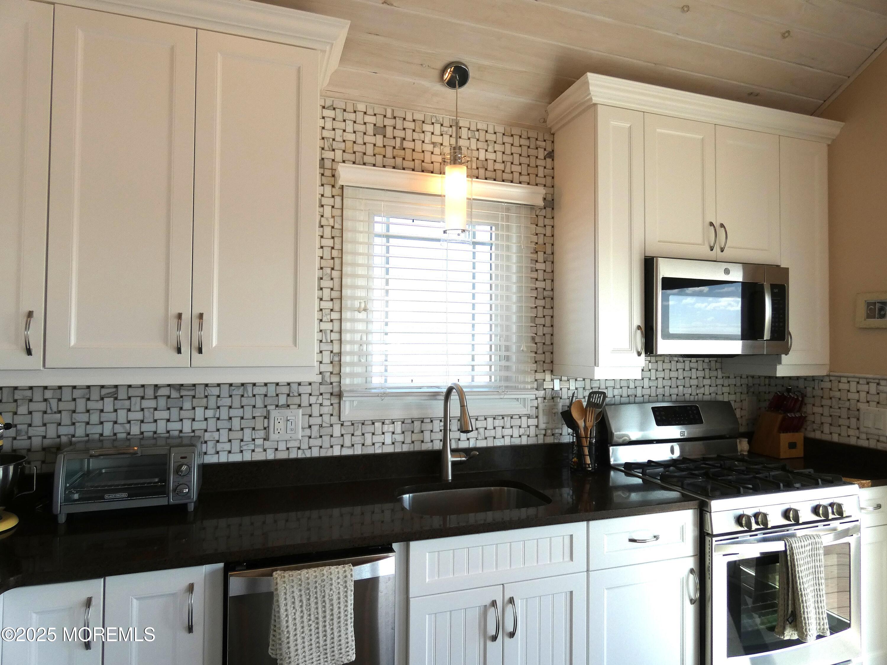 3420 Seaview Road Lavallette, NJ 08735 - Photo 9 of 44 a kitchen with granite countertop a sink a stove and cabinets
