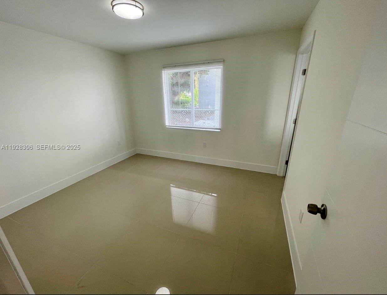 1766 Northwest 68th Terrace, Unit A Miami, FL 33147 - Photo 5 of 10 an empty room with windows