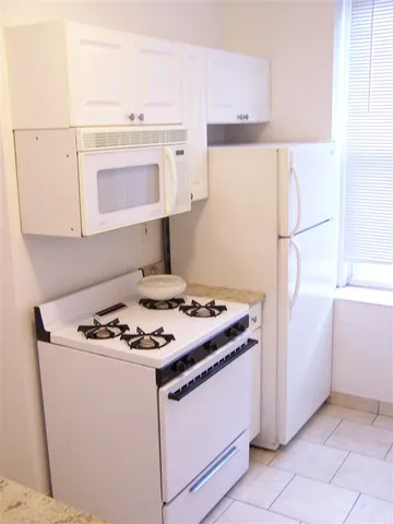 a white stove top oven sitting inside of a kitchen