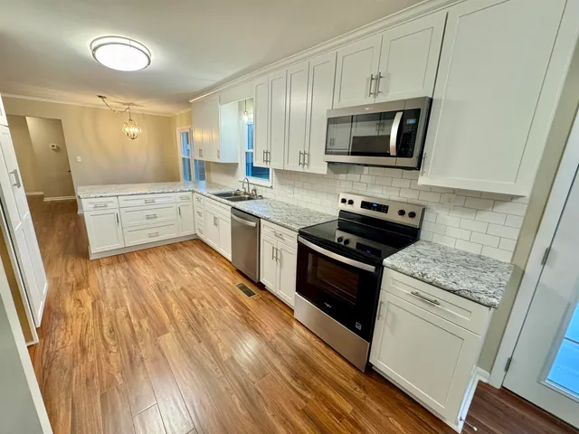a kitchen with granite countertop a sink and steel appliances