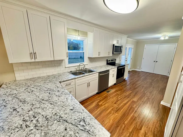 a kitchen with white cabinets and stainless steel appliances