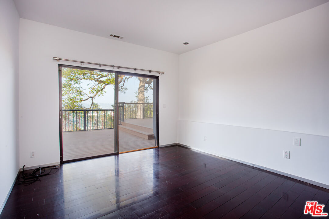 1925 Walcott Way Los Angeles, CA 90039 - Photo 19 of 27 an empty room with wooden floor and windows