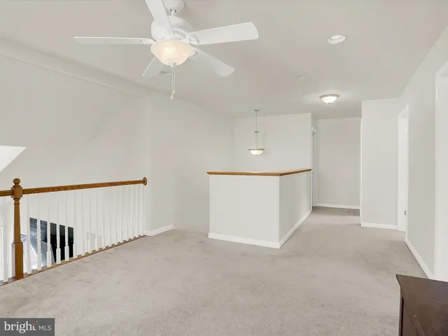 a view of an empty room with a ceiling fan