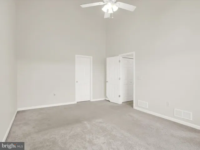 an empty room with a chandelier fan